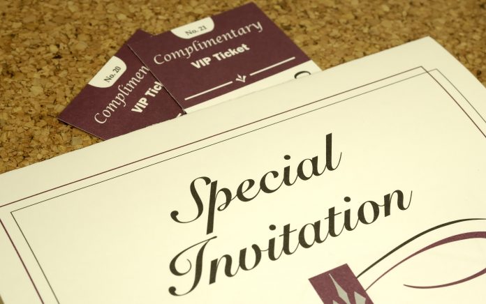 Special invitation and VIP tickets on a corkboard, symbolising the planning and exclusivity involved in being an event planner