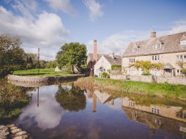 Picturesque countryside cottage by a serene river, representing the charm of Airbnb hosting in the UK