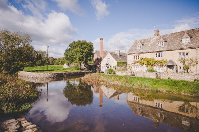 Picturesque countryside cottage by a serene river, representing the charm of Airbnb hosting in the UK