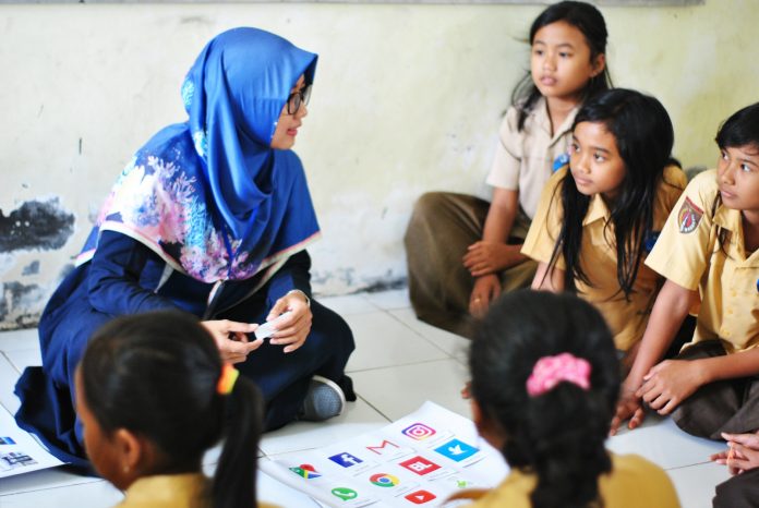 A tutor engaging with students in a classroom setting, representing the start of a freelance tutoring business