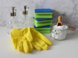 House cleaning supplies including gloves, sponges, and cleaning solutions neatly arranged on a countertop