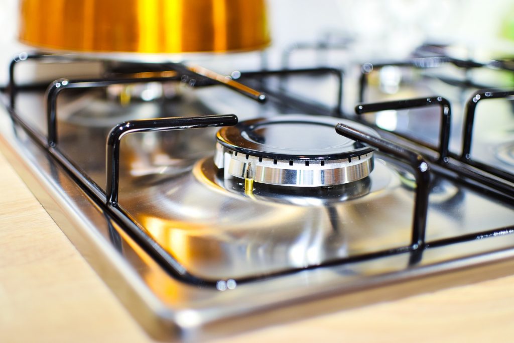 Close-up of a clean and polished gas stove burner in a well-maintained kitchen