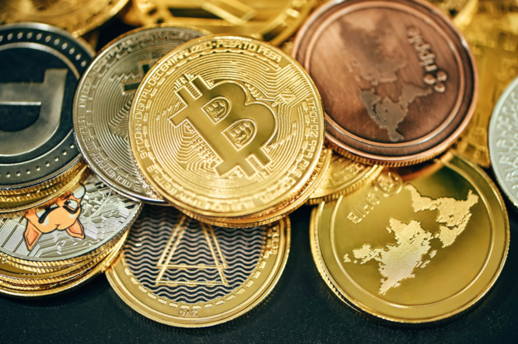 A close-up of various cryptocurrency coins including Bitcoin, Litecoin, and others, symbolizing the diverse investment opportunities in cryptocurrency